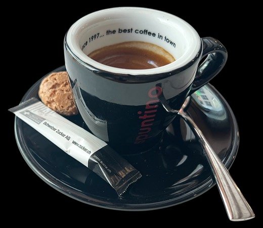 Kaffee in der schwarzen spuntino-Tasse mit Amaretti, Zucker-Stick und Löffel auf dem Untersatz.